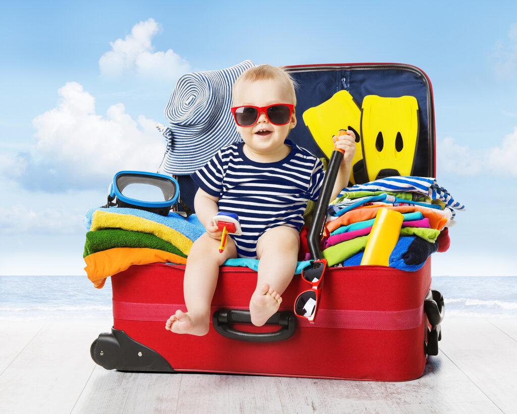 Baby In Travel Suitcase. Kid Inside Luggage Packed For Vacation